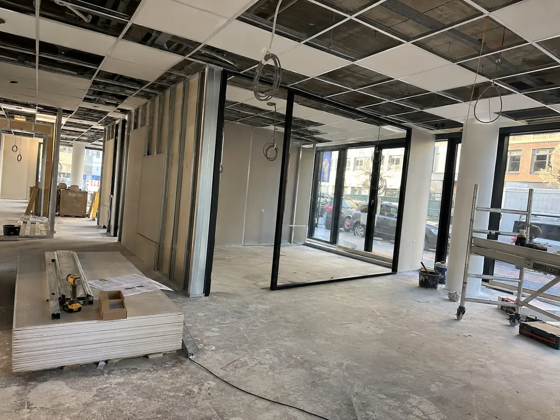 Werffoto kantoor: metalen wandstructuur, zwart kader voor de glaswand en systeemplafond in opbouw