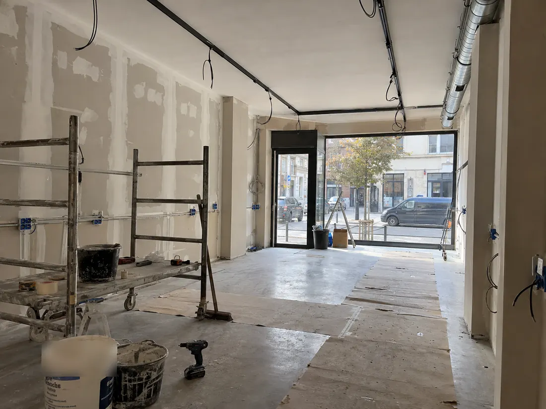 Werffoto winkel: wanden in afwerking, nieuwe stopcontacten en zwarte verlichtingsrails aan het plafond