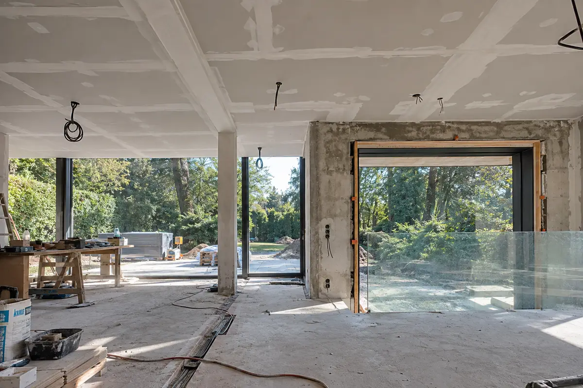 Dezelfde leefruimte tijdens de renovatie: ruwbouw, gyprocplafond en technieken